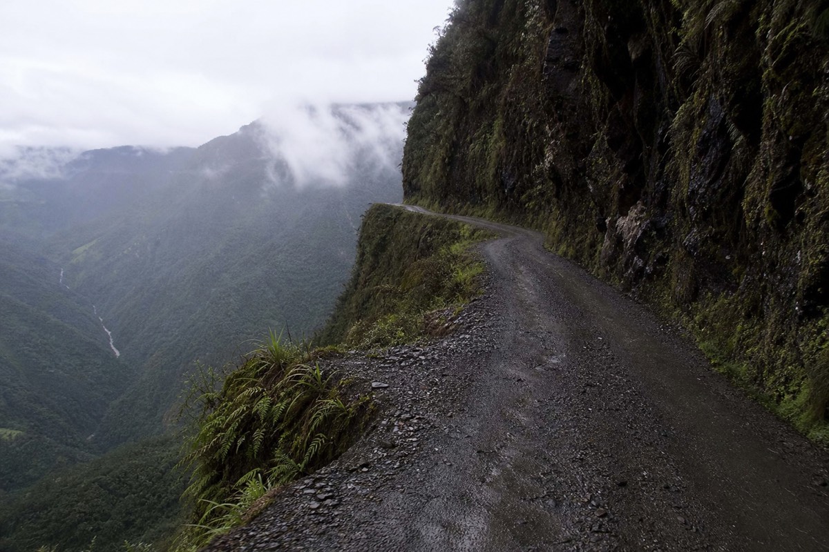 A narrow cliff section of the Death Road carved into a sheer Bolivian mountainside